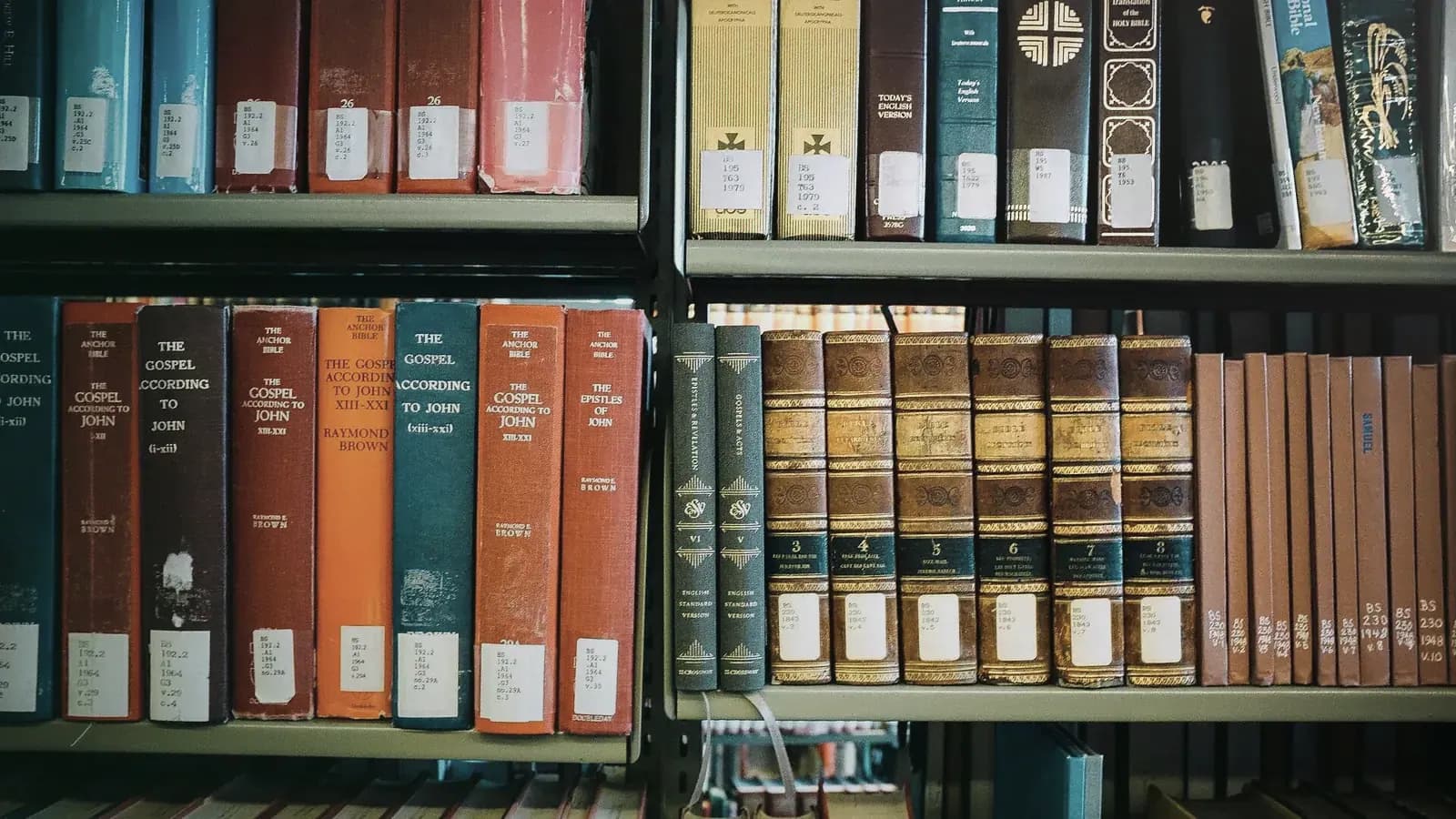 Deux étagères de bibliothèque garnies de volumes reliés aux tranches colorées