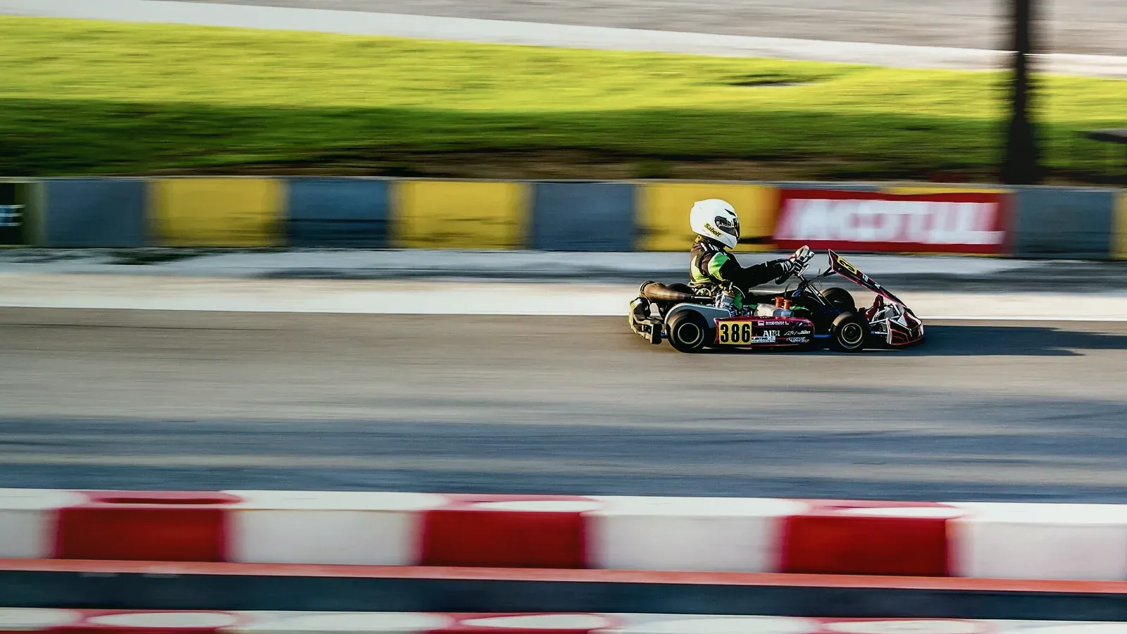 Kart lancé sur un circuit, décor filé par la vitesse en arrière-plan
