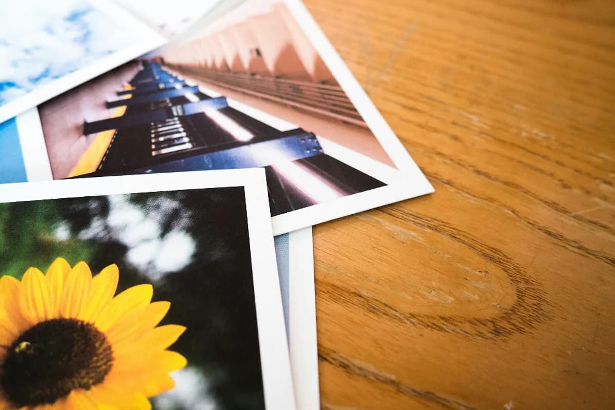 Tirages photo aux couleurs vives posés sur une table en bois, avant et après retouche