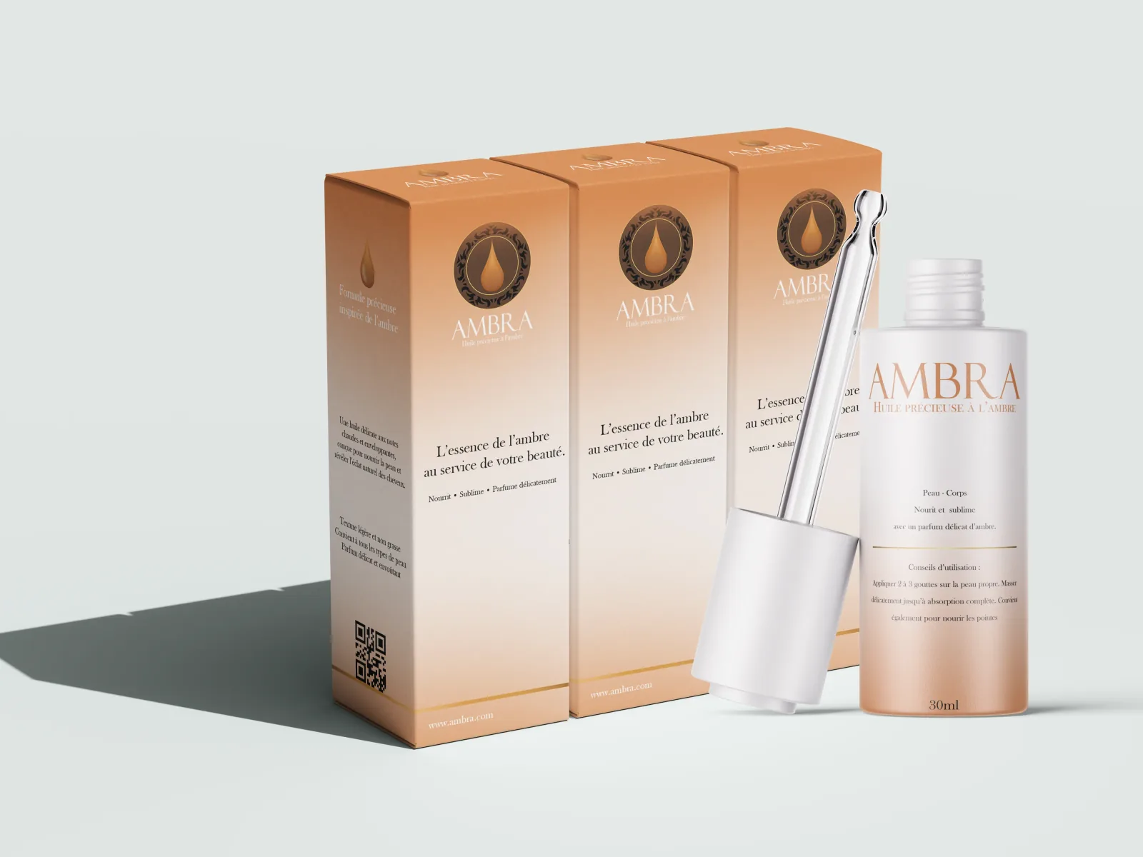 Packaging de sérum cosmétique : trois étuis cartonnés en dégradé ambré alignés derrière un flacon de 30 ml et sa pipette, sur fond gris clair, avec un pictogramme de goutte et des mentions en capitales espacées